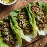 Ground beef wrap lettuce on rustic plate with sesame and scallions