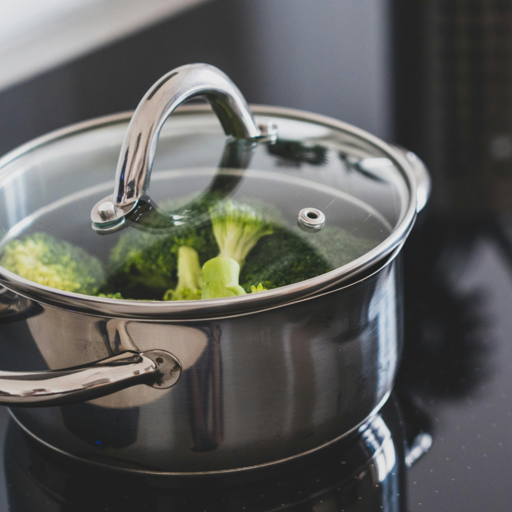 A stainless steel stock pot with lid on a stove, ideal for one-pot soups and stews like lasagna soup.